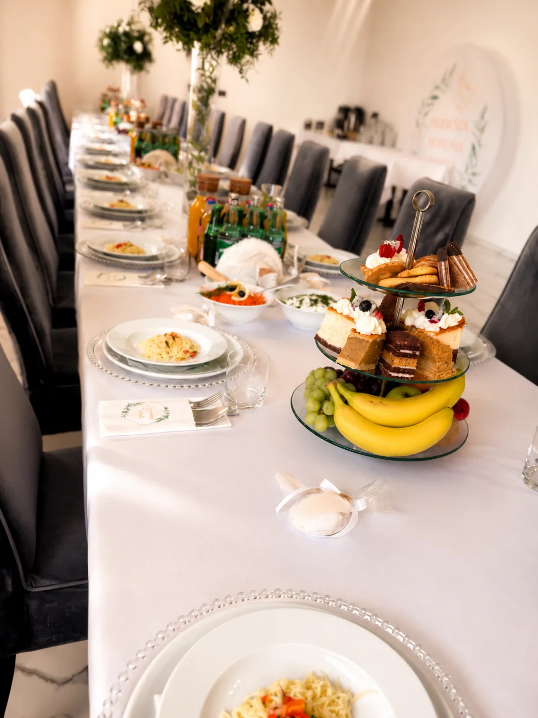 Długi nakryty stół bankietowy z białym obrusem i zastawą w sali restauracji Fantazja.