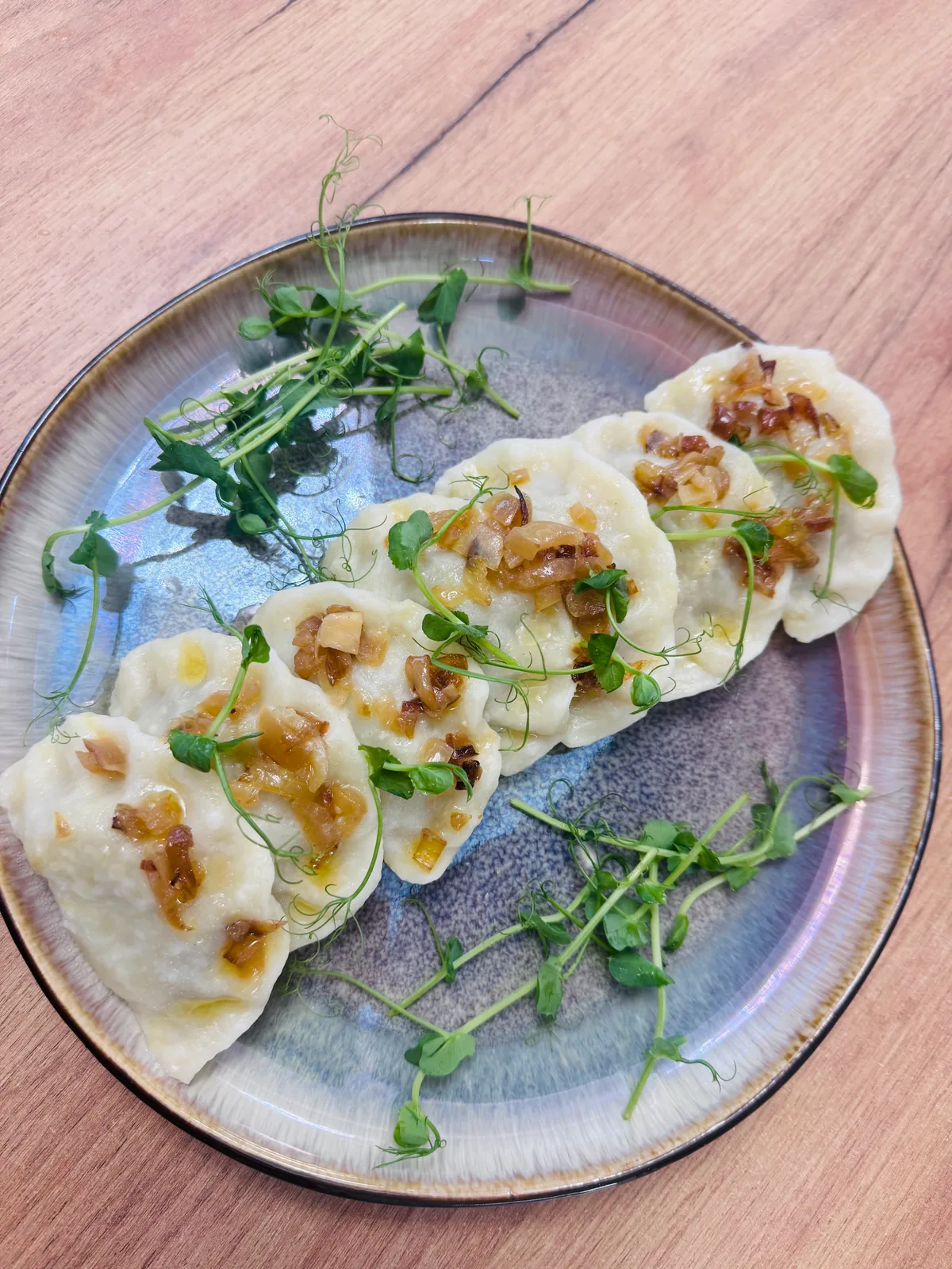 Pierogi z ziołami i rukolą podane na talerzu w Restauracji Fantazja.